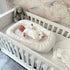 Baby liegt im Babynest Boucle weiß im Babybett Royal